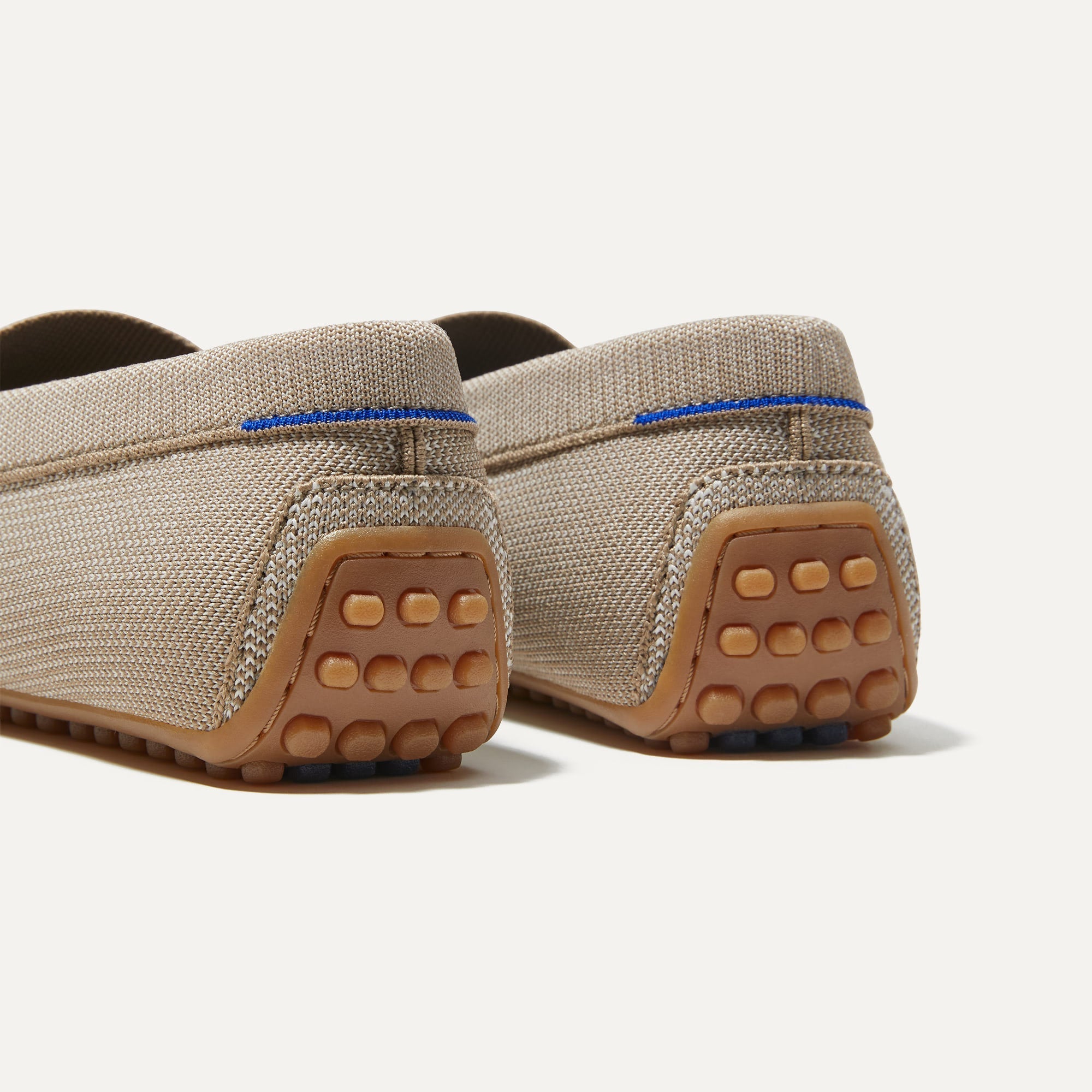Close up of the heel of The Driving Loafer in Barley, with raised nub outsoles and Rothy's signature blue halo. 